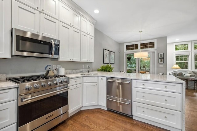 kitchen with sink, white cabinets, stainless steel appliances, and wood-type flooring