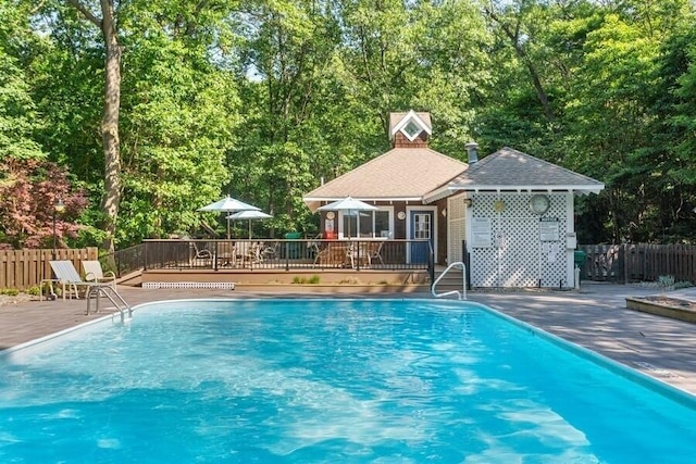 view of swimming pool with an outbuilding, a patio, and a wooden deck