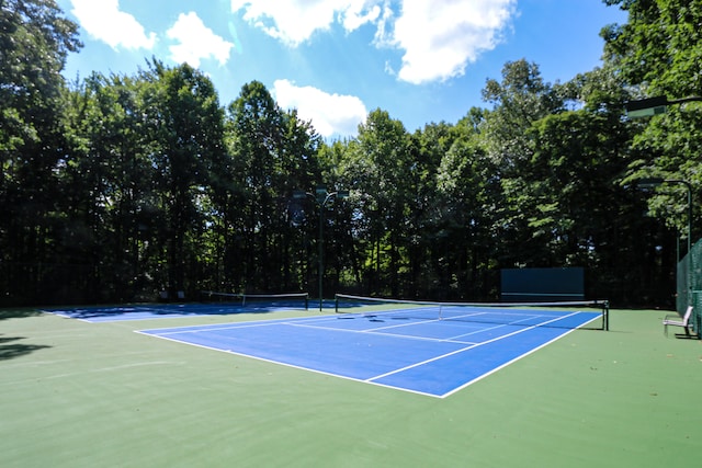 view of tennis court featuring basketball hoop