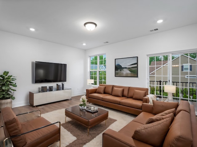 living area with visible vents, recessed lighting, baseboards, and wood finished floors