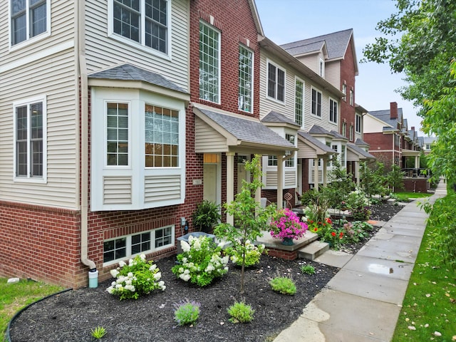 exterior space featuring a residential view and brick siding