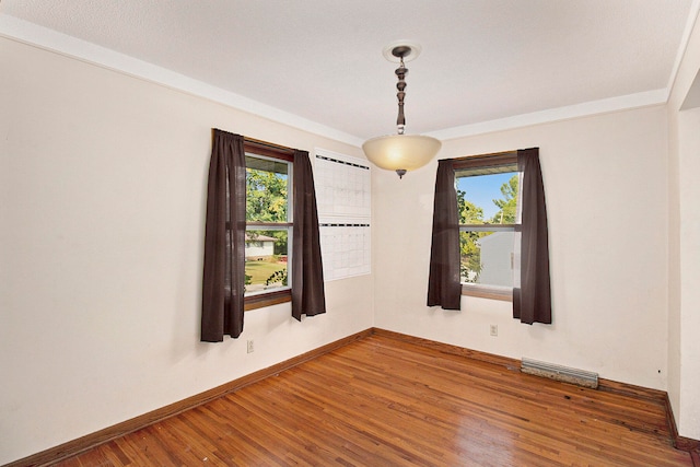 spare room featuring hardwood / wood-style floors and a healthy amount of sunlight