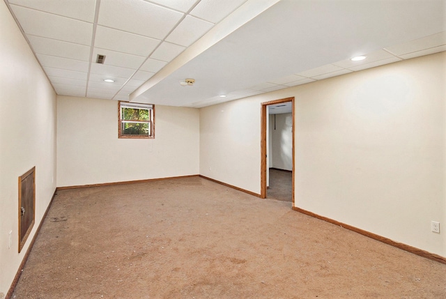 basement featuring a drop ceiling and light colored carpet