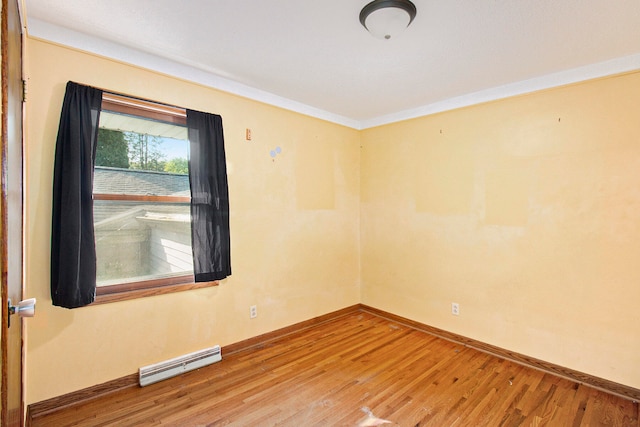 unfurnished room with wood-type flooring and a baseboard radiator