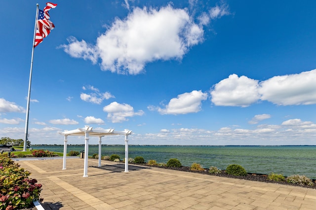 view of patio featuring a pergola and a water view