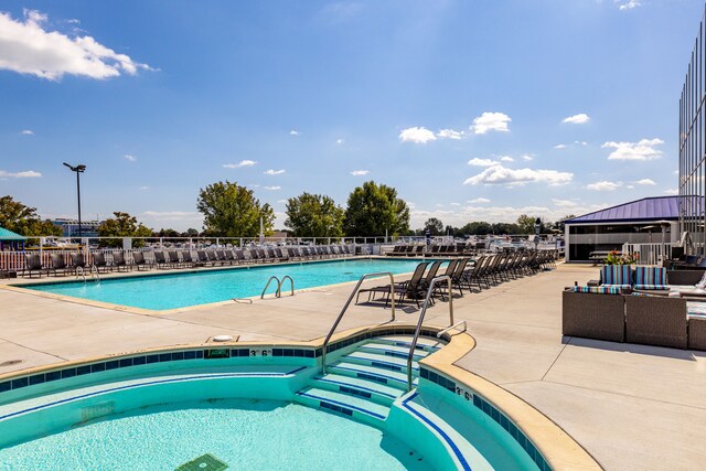 view of swimming pool with a hot tub and a patio area