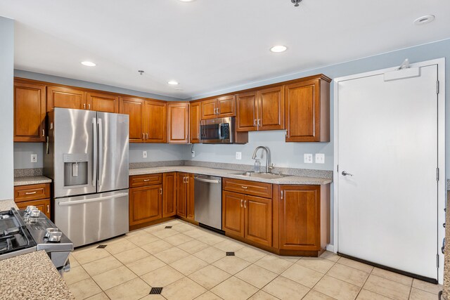 kitchen featuring light tile patterned floors, stainless steel appliances, and sink