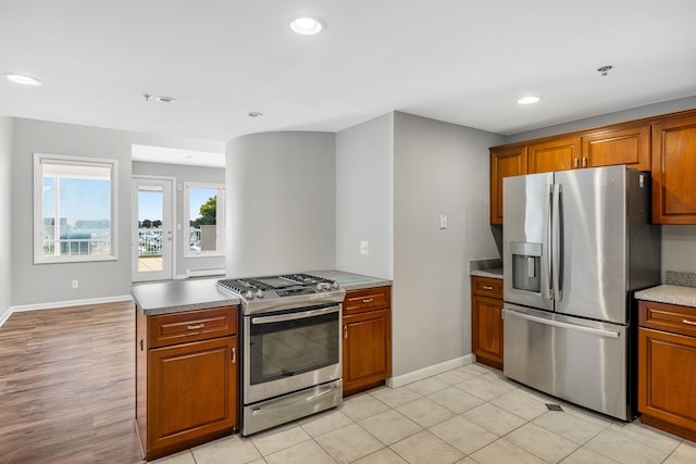 kitchen featuring kitchen peninsula, stainless steel appliances, and light tile patterned flooring