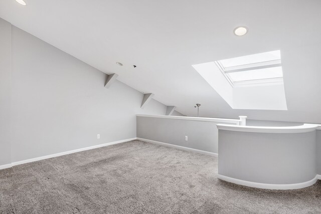 bonus room with carpet flooring and lofted ceiling with skylight