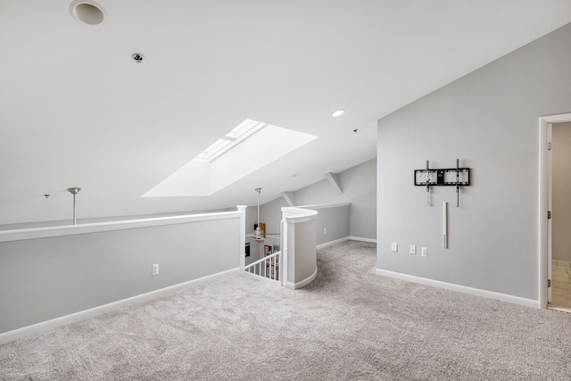 additional living space with carpet floors and lofted ceiling with skylight