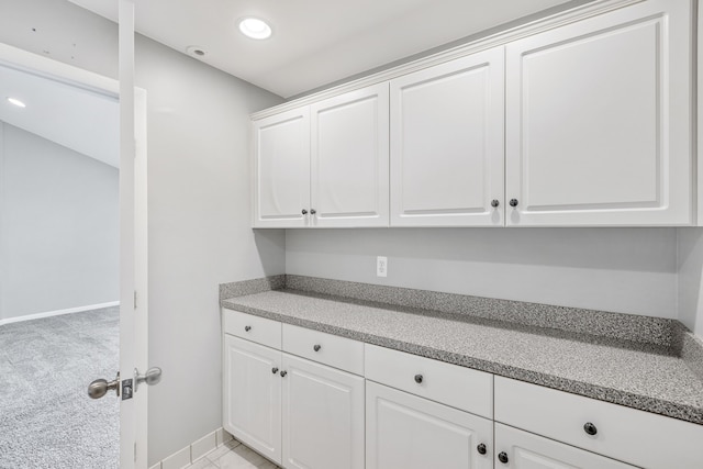 clothes washing area with light colored carpet