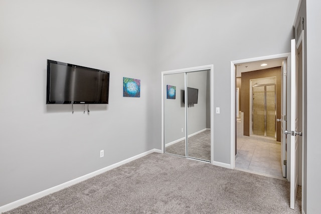 unfurnished bedroom featuring a closet and light colored carpet