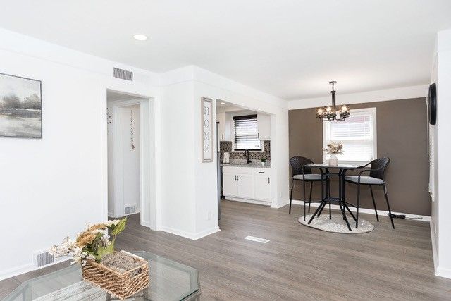 8410 Grandville Ave, Detroit, MI 48228 - living room with a chandelier, wood finished floors, baseboards, and recessed lighting