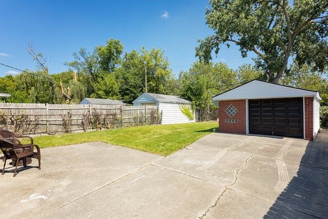 view of patio with a garage and an outbuilding