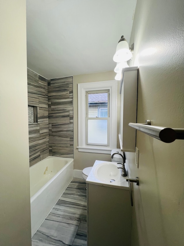 full bathroom featuring vanity, tiled shower / bath combo, and toilet