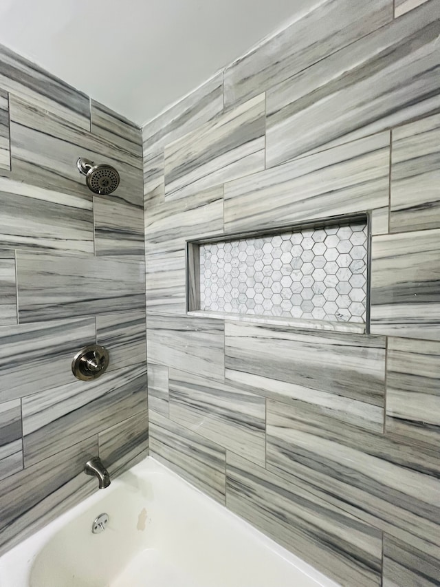 bathroom featuring tiled shower / bath