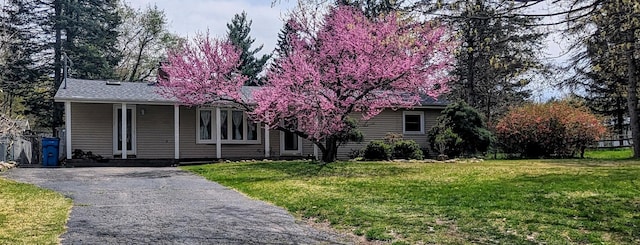 view of property hidden behind natural elements featuring a front yard