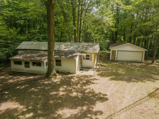11451 Hemlock Ave, Lake, MI 48632 - view of front of home featuring a detached garage, an outbuilding, and a wooded view