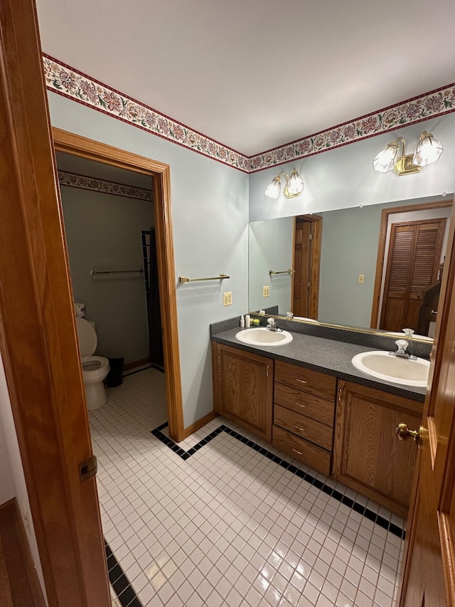 bathroom with tile patterned floors, vanity, and toilet