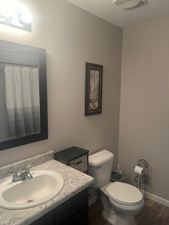 bathroom featuring hardwood / wood-style floors, vanity, and toilet