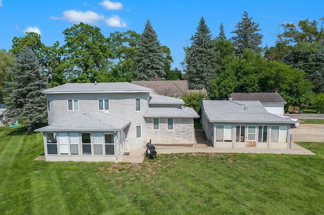 rear view of house featuring a lawn and a patio