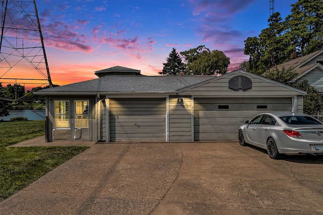 exterior space with a garage, a shingled roof, and driveway