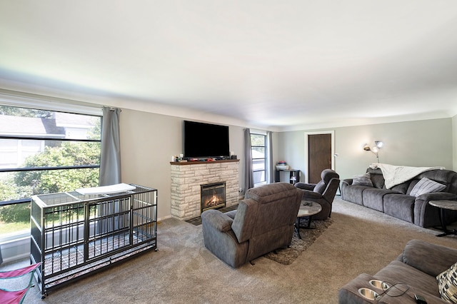 carpeted living room with a stone fireplace