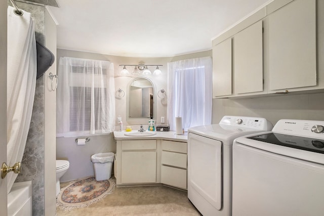 laundry area with laundry area, a sink, and washing machine and clothes dryer