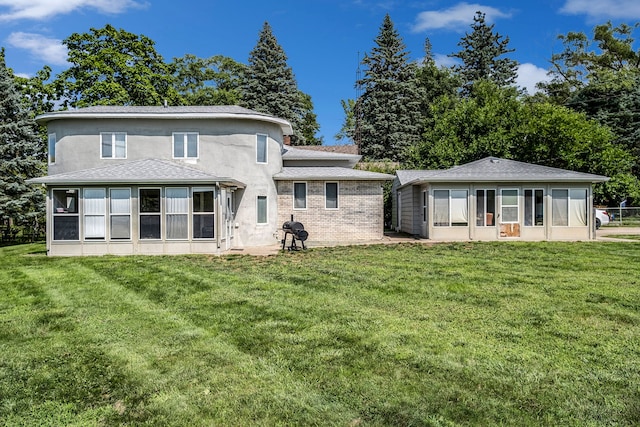 back of house featuring a yard and a sunroom