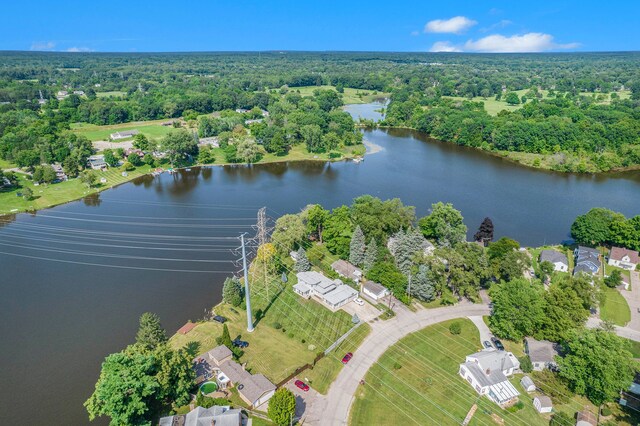 bird's eye view with a water view and a wooded view