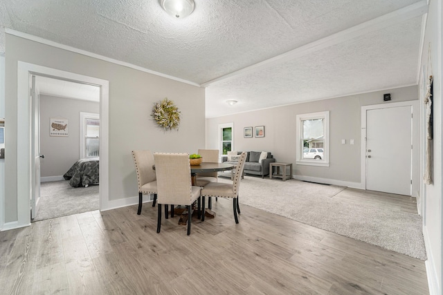 dining space featuring a textured ceiling and light wood-type flooring