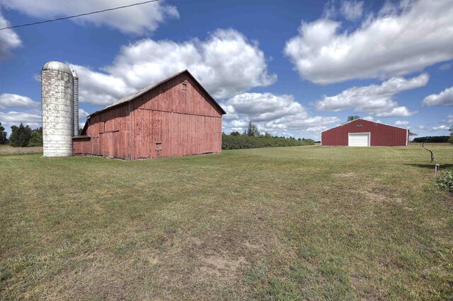 20682 Honor Hwy, Interlochen, MI 49643 - view of green lawn featuring a detached garage, an outbuilding, and a barn
