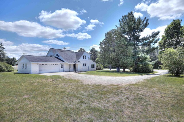 20682 Honor Hwy, Interlochen, MI 49643 - view of property exterior with dirt driveway, a garage, and a lawn