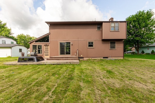 rear view of house featuring a yard and a deck