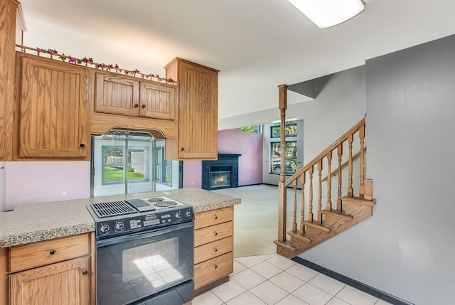 kitchen with electric range and light colored carpet