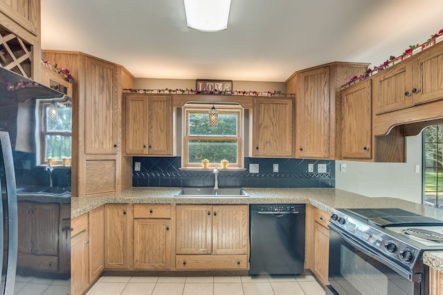 kitchen with light tile patterned floors, sink, backsplash, and black appliances