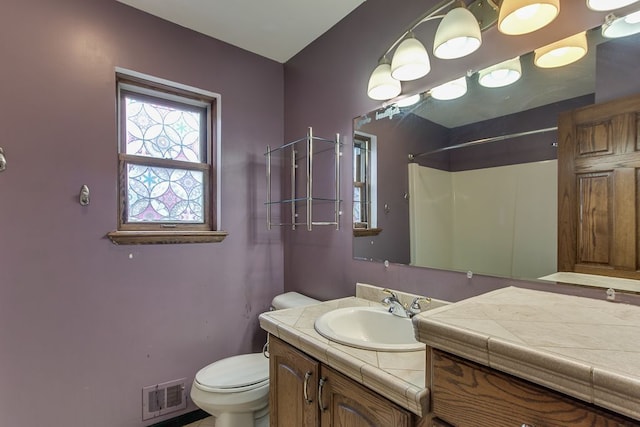 bathroom with vanity, toilet, and walk in shower