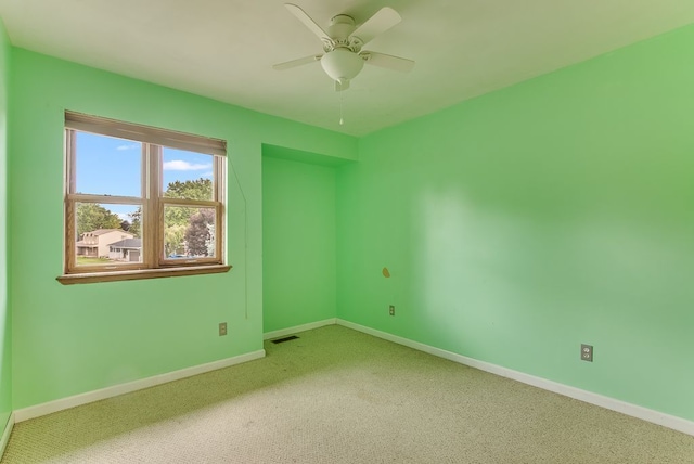 unfurnished room with ceiling fan and carpet