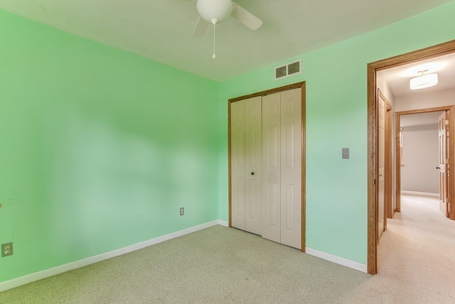 unfurnished bedroom with light colored carpet, a closet, and ceiling fan