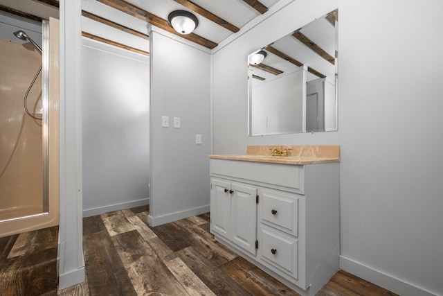 bathroom featuring beamed ceiling, vanity, wood-type flooring, and walk in shower