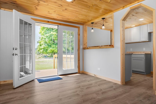 doorway featuring light wood-type flooring and wooden ceiling