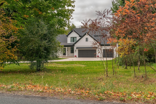 traditional-style house with an attached garage and a front yard