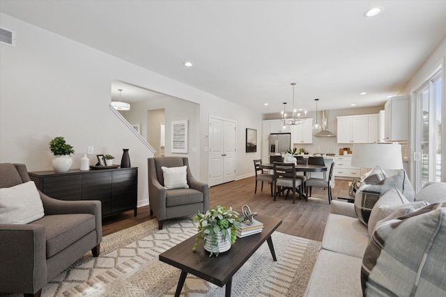 living area featuring light wood-style floors, recessed lighting, visible vents, and baseboards