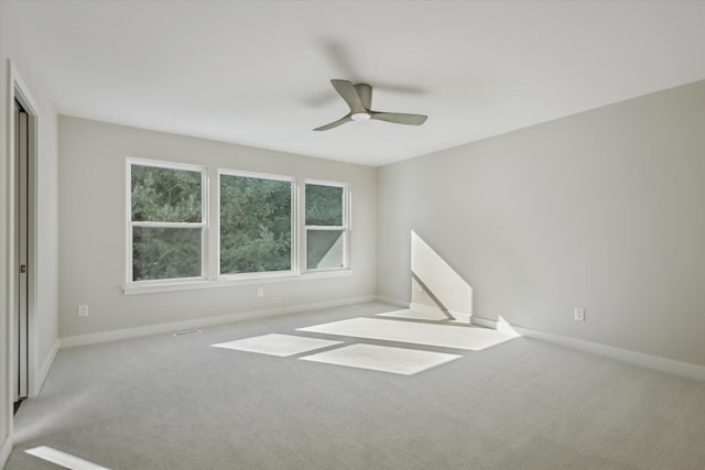 spare room with carpet, ceiling fan, and baseboards