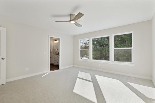 unfurnished bedroom featuring visible vents, baseboards, a ceiling fan, ensuite bath, and carpet flooring