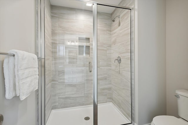 bathroom featuring a stall shower and toilet