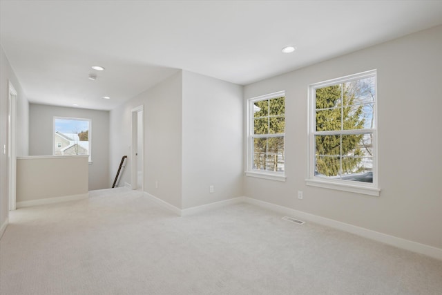 carpeted spare room featuring baseboards, visible vents, and recessed lighting