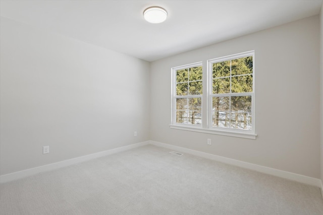 unfurnished room with light carpet, visible vents, and baseboards