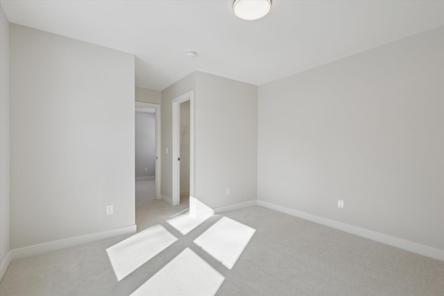 unfurnished bedroom featuring light carpet and baseboards