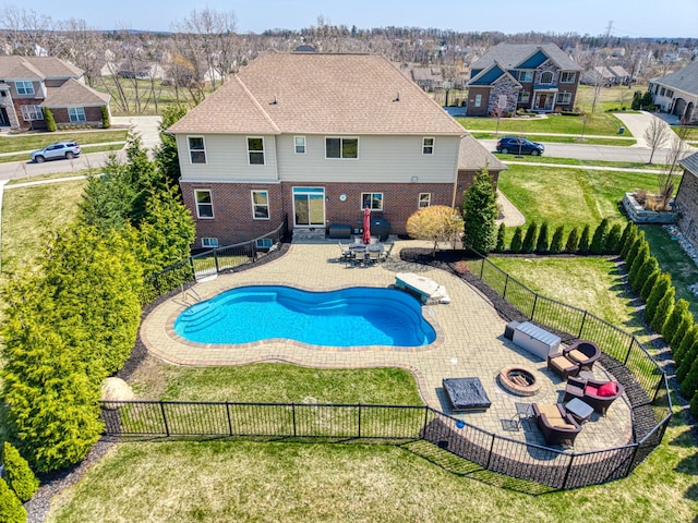 view of pool featuring a fire pit, a residential view, a lawn, and a patio